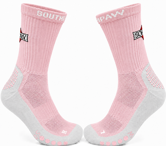 A pair of pink and gray athletic crew socks with grip dots on the toes and heels, featuring the brand name 'SOUTHPAW' on the cuffs.