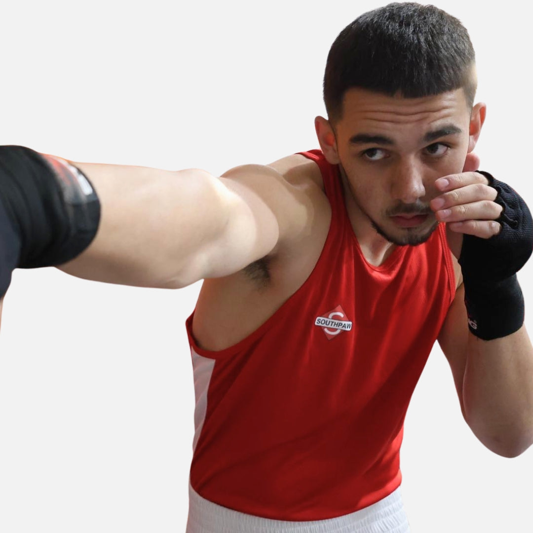 Boxer throwing punch in Southpaw red boxing kit showing freedom of movement