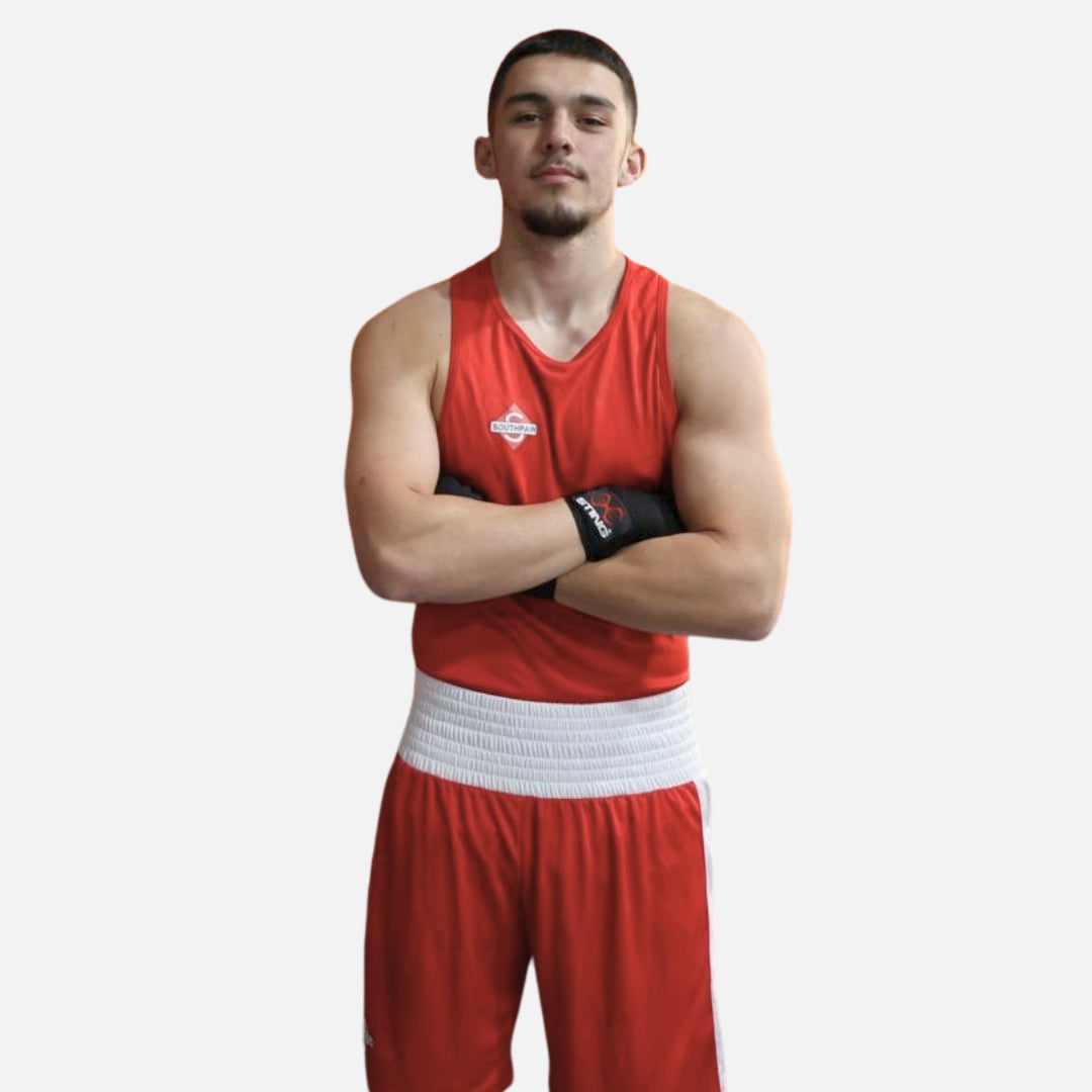 Boxer wearing Southpaw red boxing vest and shorts front view showing athletic fit.