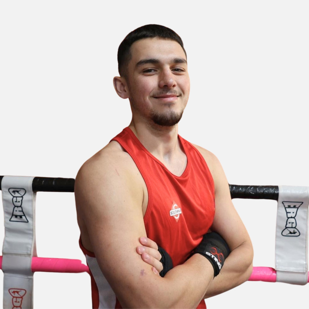 Southpaw red boxing vest and shorts in boxing ring in authentic gym environment.